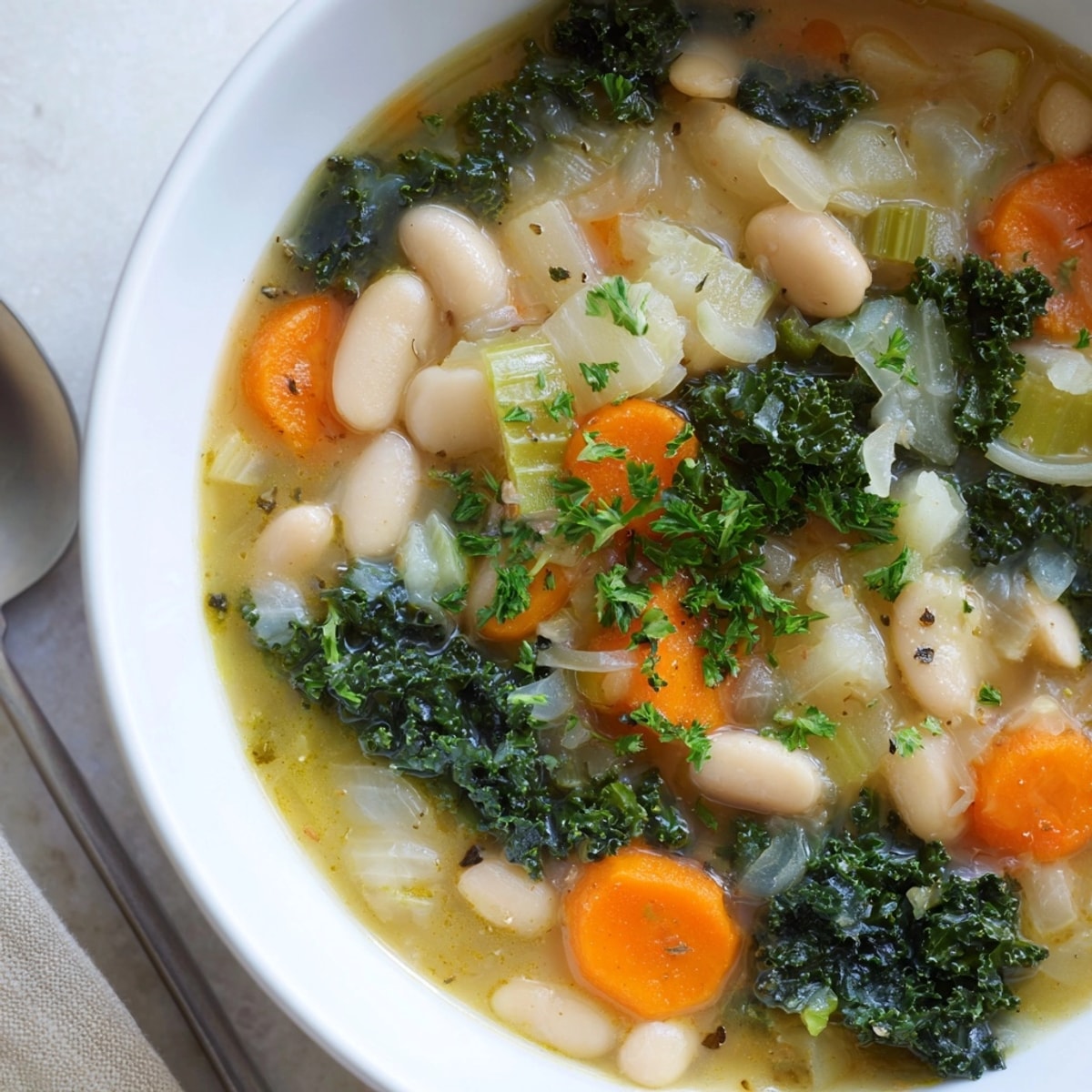 Ladling hot White Bean and Kale Soup garnished with fresh parsley. Comforting and delicious.