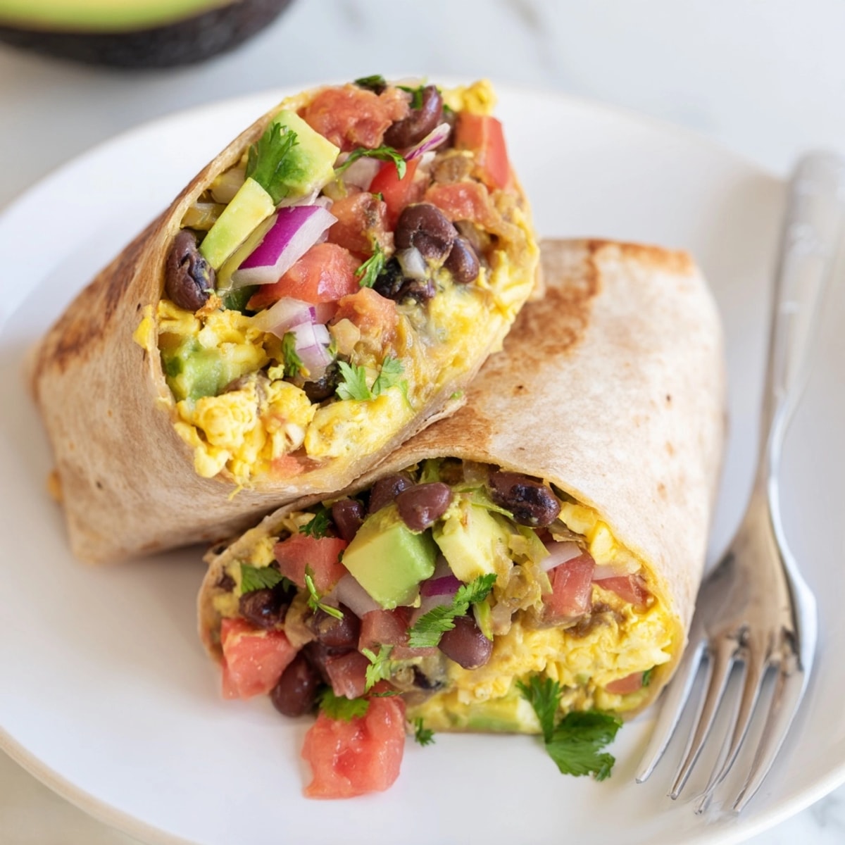 Golden-brown Avocado Southwest Breakfast Burrito, packed with savory eggs, beans, cheese, and fresh salsa.