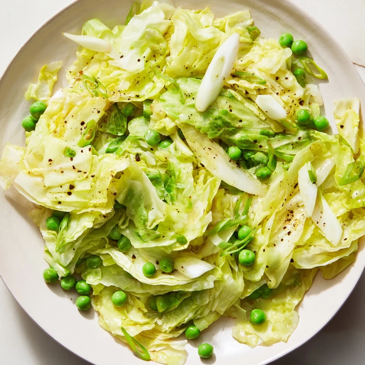 A delicious close-up of Cabbage Stir-Fry, featuring vibrant peas and savory garlic-soy sauce.