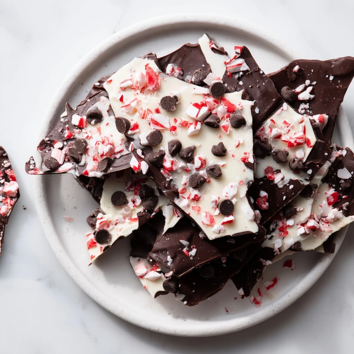 Peppermint bark shards scattered on a wooden board ready for sharing, a festive treat.