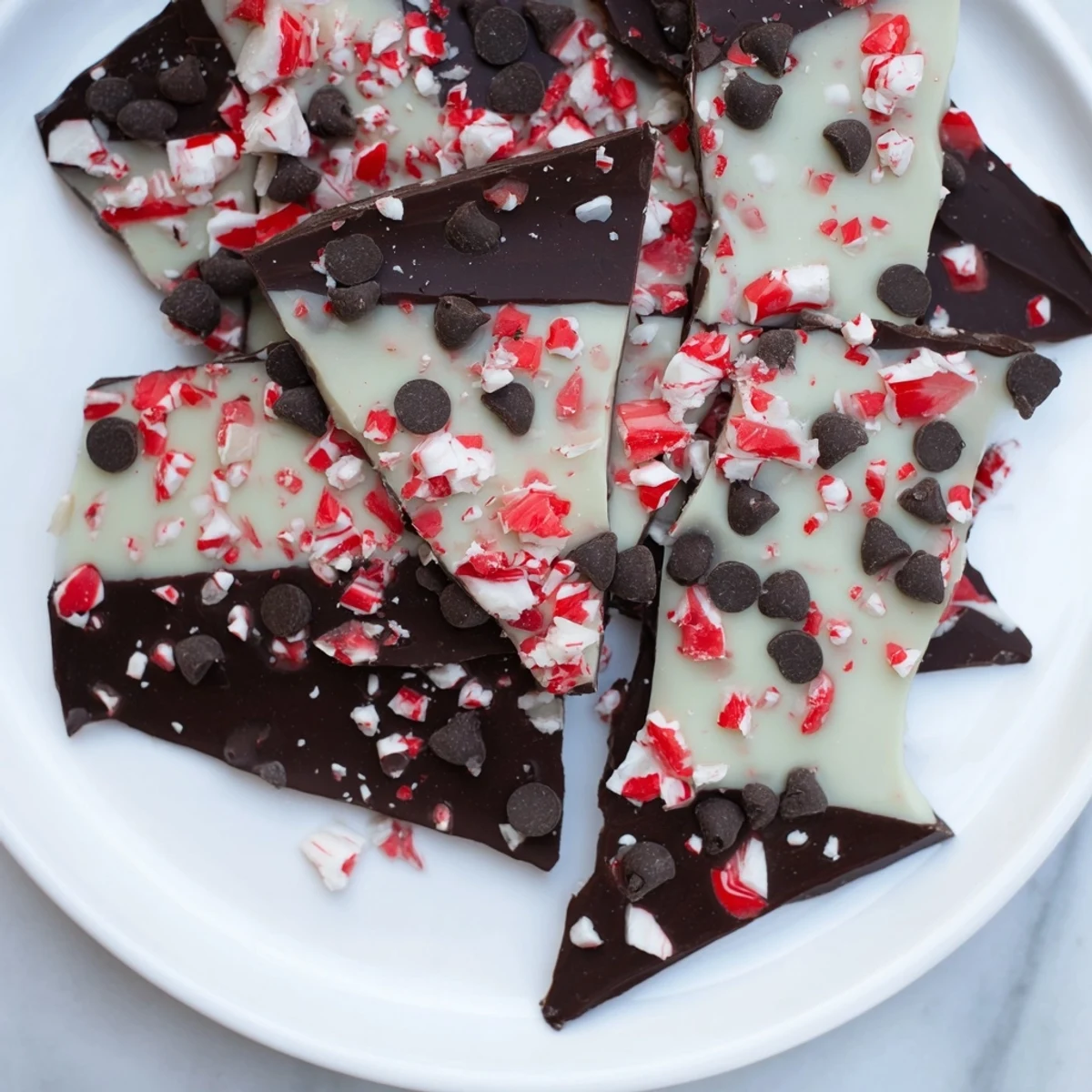 Freshly made peppermint bark shards glistening with crushed peppermint, perfect for holiday gatherings.
