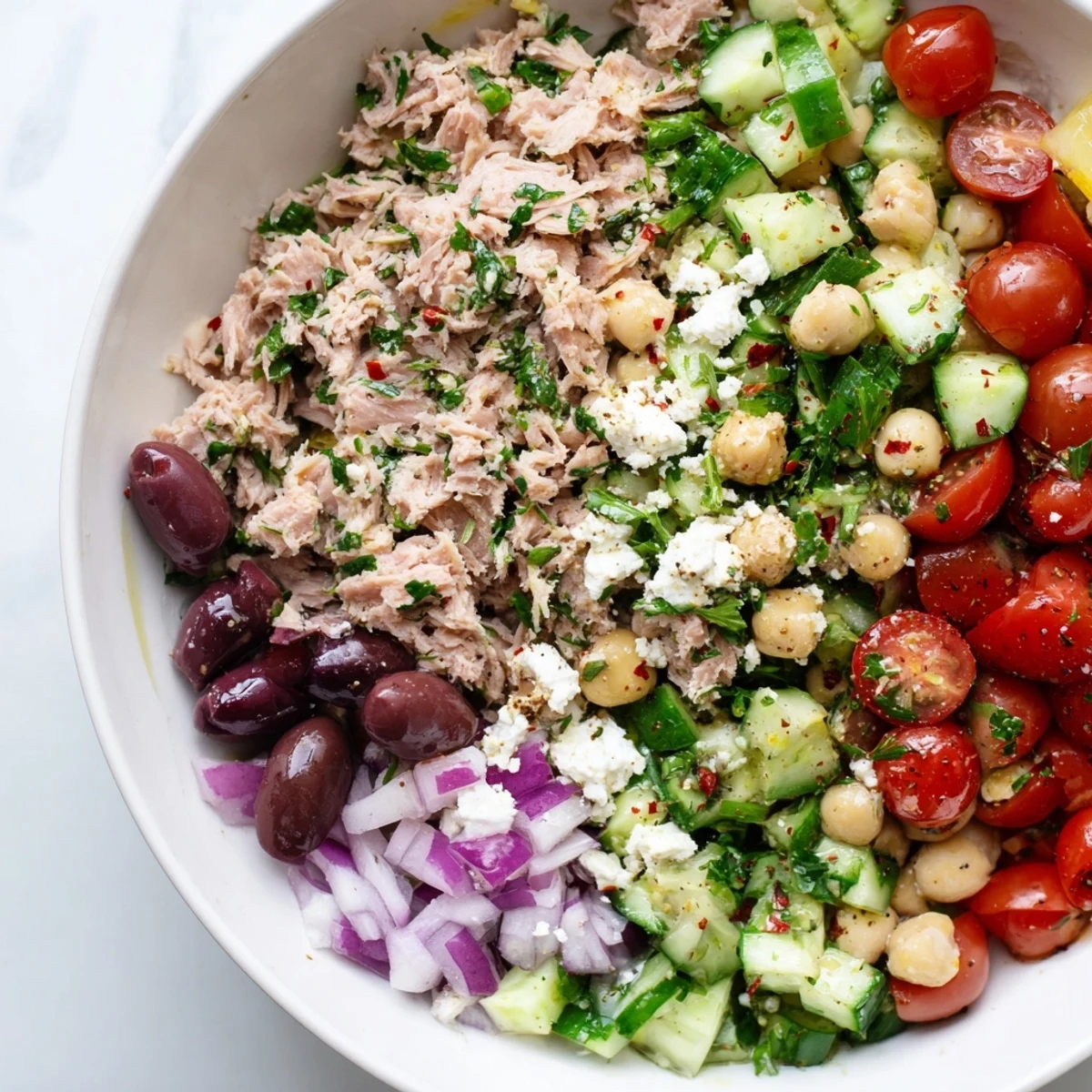A delicious bowl of Tuna Chickpea Salad with olives, and parsley; perfect for lunch!
