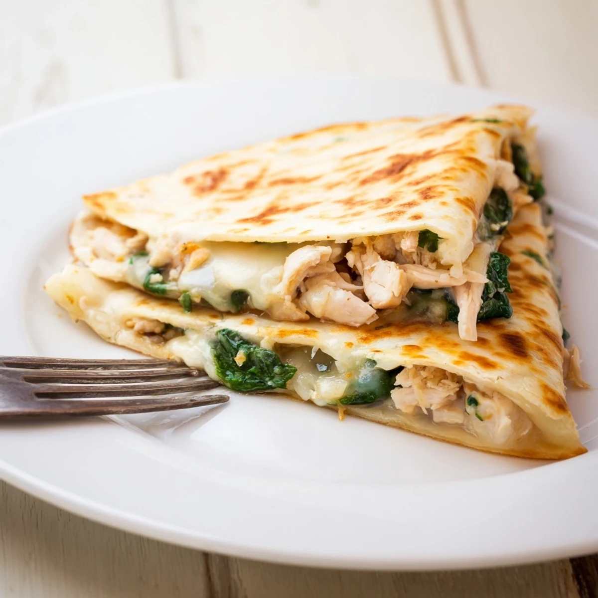 Homemade Chicken and Spinach Quesadilla cut into triangles, perfect for an easy weeknight dinner.