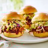 Succulent pulled BBQ chicken sliders with creamy tangy slaw nestled in buttered mini buns, perfect for a casual backyard dinner.