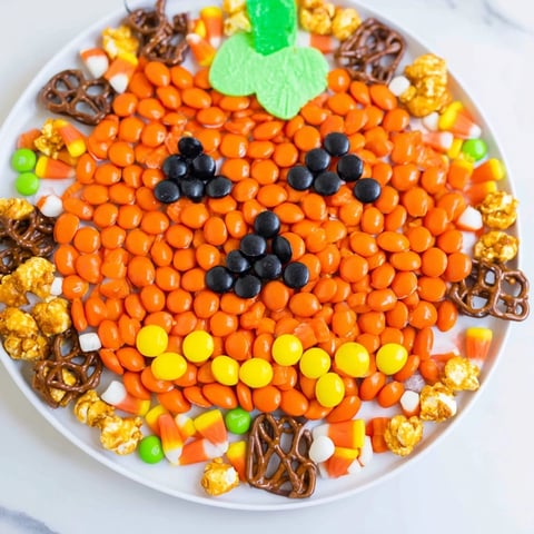 Vibrant Jack-o-Lantern candy board, overflowing with colorful candies for a fun Halloween dessert.