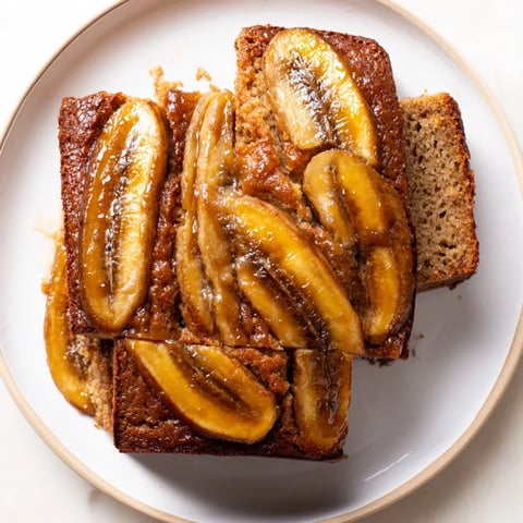 Golden caramelized bananas atop a warm and inviting slice of banana bread cake.