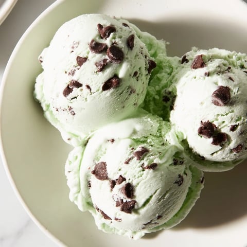 Swirls of creamy Mint Chocolate Chip Ice Cream, perfect for a refreshing summer dessert.