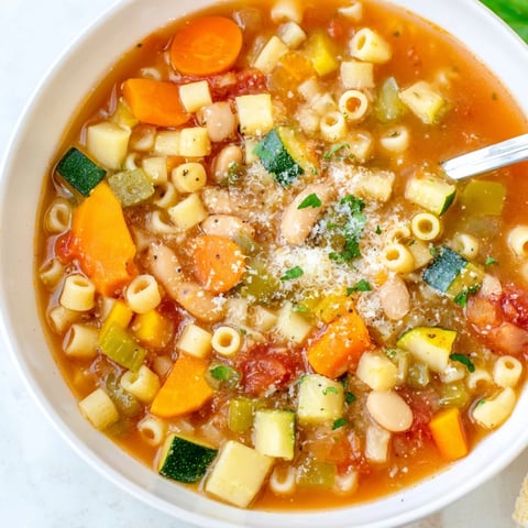 Hearty Minestrone Vegetable Soup simmering with colorful vegetables, cannellini beans, and ditalini pasta in a tomato-based broth.