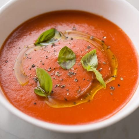 Homemade Tomato Basil Soup recipe, a vibrant red puree, ready to be enjoyed with crusty bread.