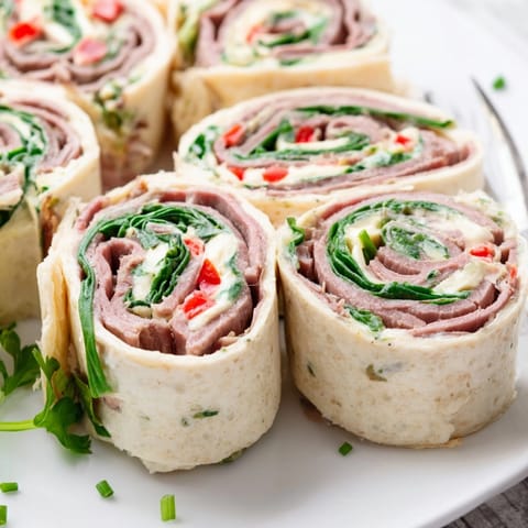 Rolled Cajun Roast Beef Pinwheel Rolls, chilled and sliced, perfect for easy serving.