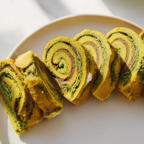 Delicate matcha pumpkin roulades topped with luscious cream, a delicious twist on dessert.  