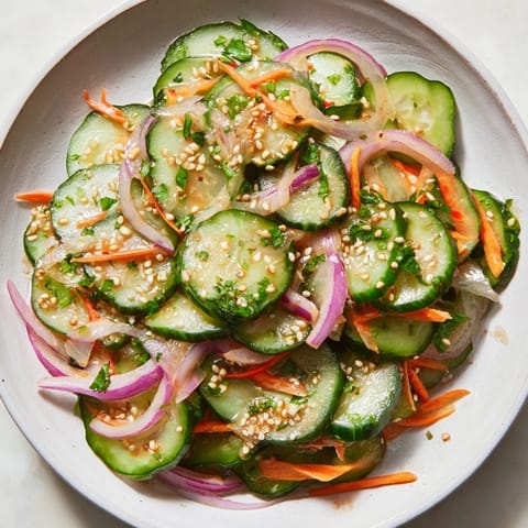 Vibrant cucumber salad remix drizzled with sesame oil and garnished with sesame seeds.  