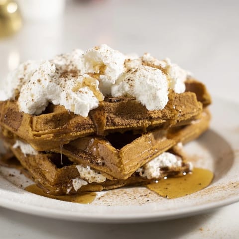 Indulge in these Express Gingerbread Waffle Stacks, golden-brown and layered with whipped cream - a cozy treat.