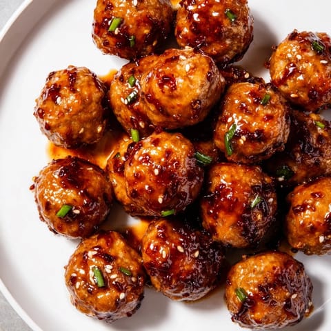 Tender, honey-glazed Spicy Chicken Meatballs glistening on a plate, perfect for a flavorful weeknight meal.