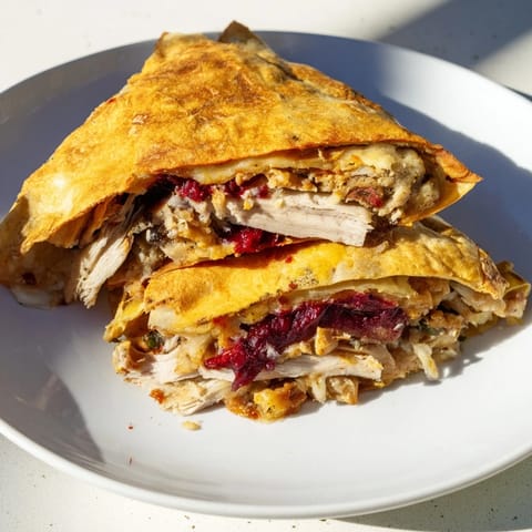 Cheesy and warm Turkey, Stuffing and Cranberry Leftovers Tortilla Wrap, showcasing a delightful holiday mashup.