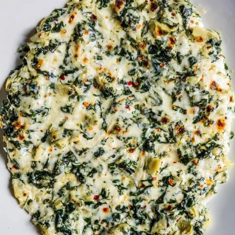 This creamy Spinach Artichoke Dip is rich with cheese, perfect for sharing at a gathering.