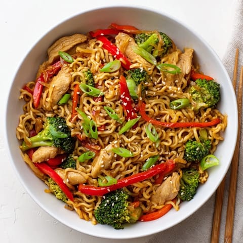 Sizzling Spicy Ramen Stir-Fry with tender chicken, crisp broccoli, and bell peppers tossed in a glossy, fiery sauce in a hot wok.