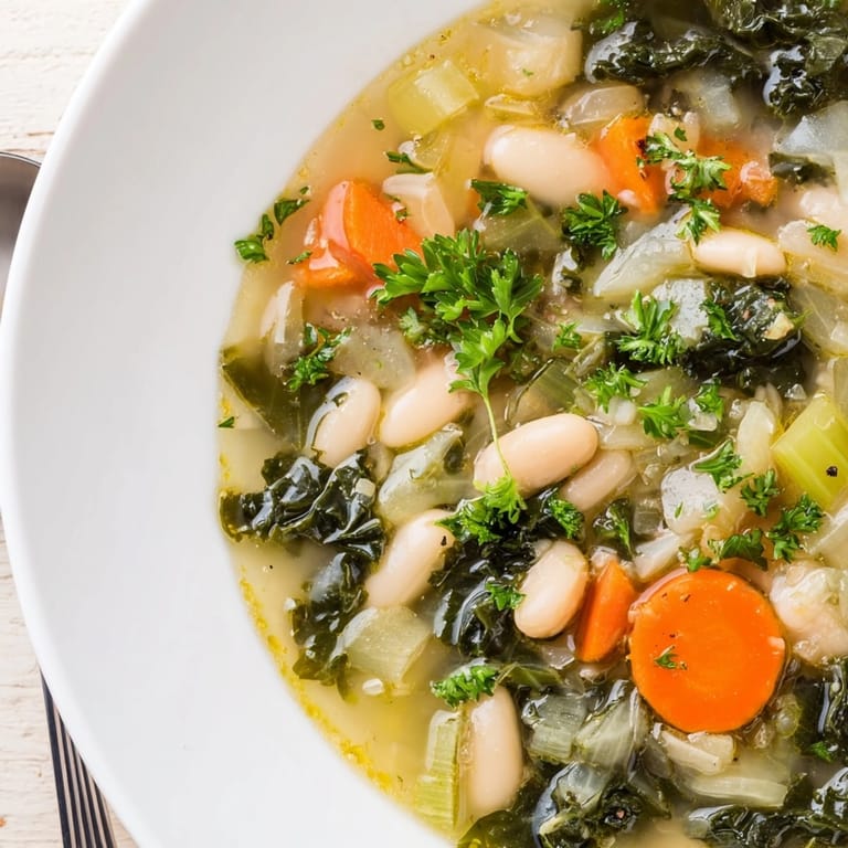 Close-up: vibrant green kale and soft white beans in homemade White Bean and Kale Soup.