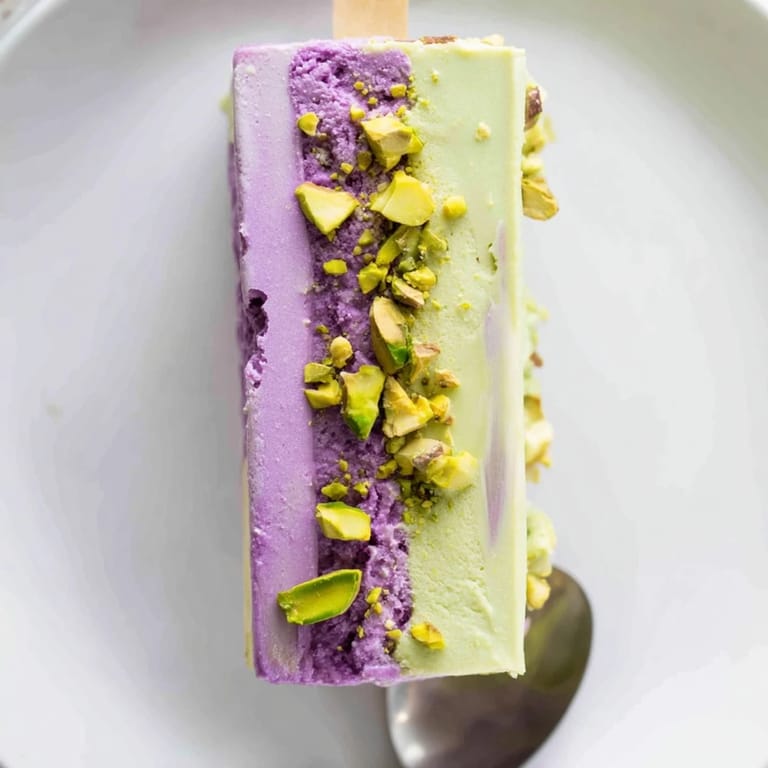 Vibrant purple ube ice cream bars layered with nutty pistachio flavor, beautifully refreshing.  