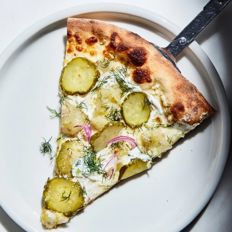 Savory pickle pizza featuring creamy sauce and golden, bubbling mozzarella cheese.