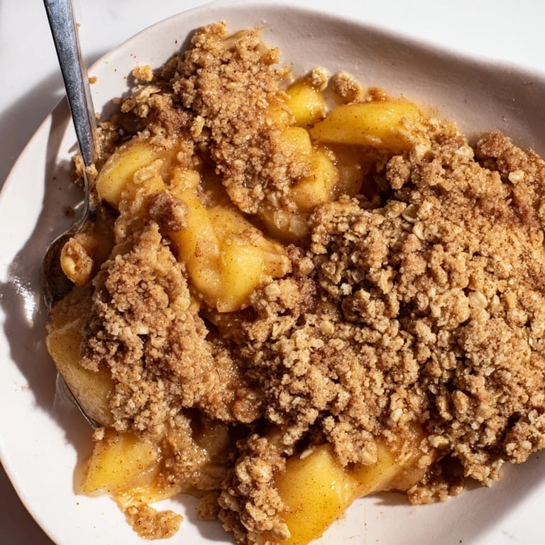 Freshly baked Apple Crisp, featuring a buttery oat crumble over sweet, tender apples cooked.