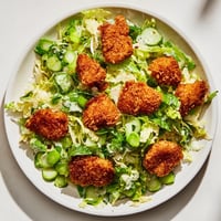 Crispy air-fried chicken nuggets atop a vibrant Green Goddess Nugget Salad with fresh herbs and creamy dressing.